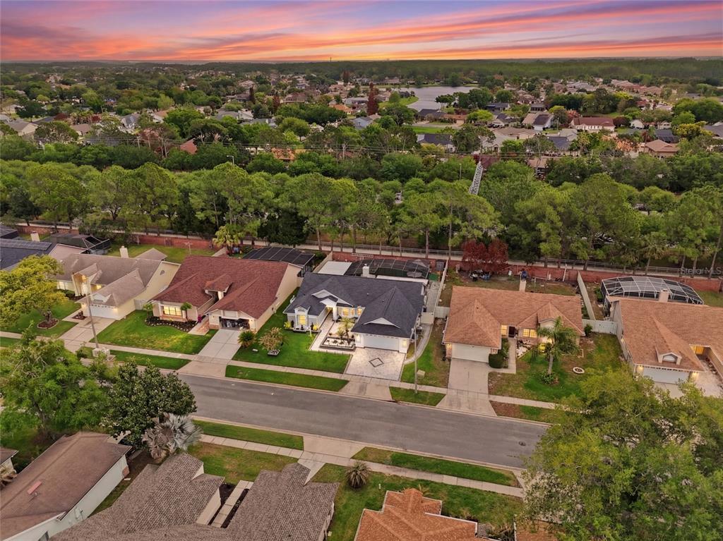 An aerial view shows a suburban street with several single-family homes and surrounding green space — 3185 TIMUCUA CIRCLE, ORLANDO, FL