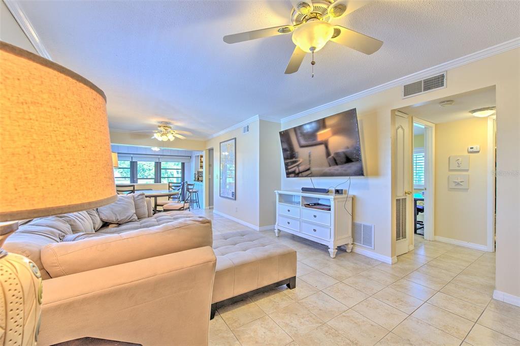 A living room features a large sectional sofa, a wall-mounted television, and tile flooring — 1008 APOLLO BEACH BOULEVARD UNIT 201, APOLLO BEACH, FL