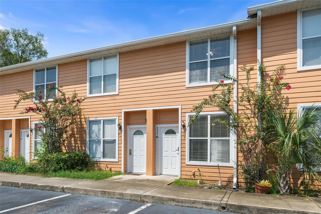 A two-story townhouse exterior with peach-colored siding, white trim, and two front entry doors — 3970 SW 20TH AVENUE UNIT 904, GAINESVILLE, FL