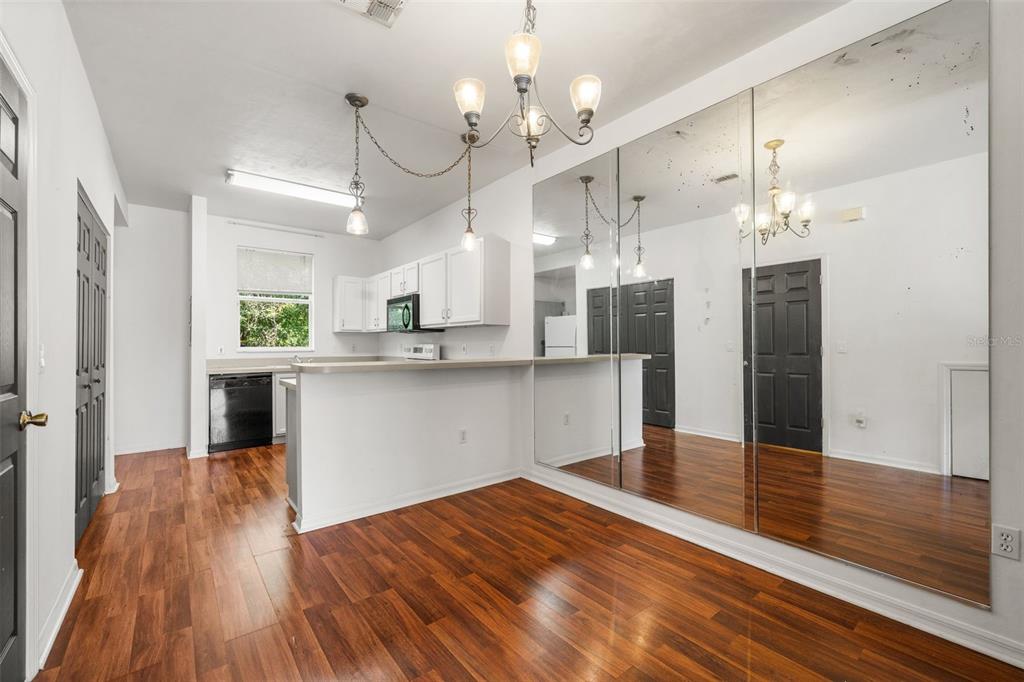 A kitchen with white cabinets, a breakfast bar, and a large mirrored wall — 3970 SW 20TH AVENUE UNIT 904, GAINESVILLE, FL