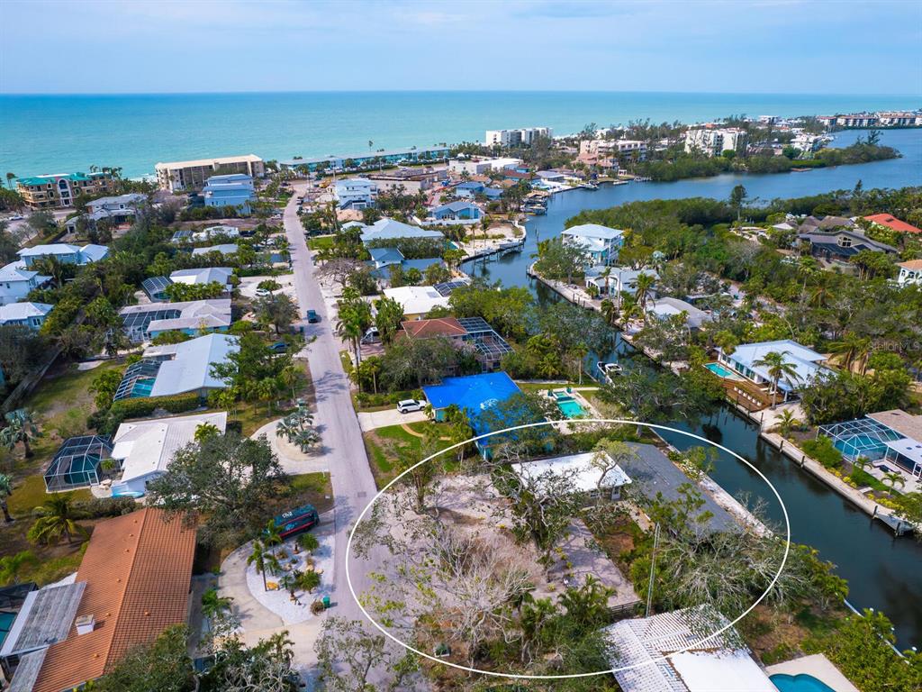 An aerial view shows a waterfront property with a house and large yard — 615 BUTTONWOOD DRIVE, LONGBOAT KEY, FL