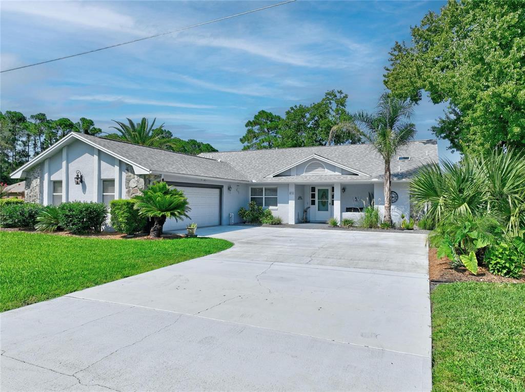 A single-story house with a gray shingled roof, light siding, and a concrete driveway — 1 WASHWELL PLACE, PALM COAST, FL