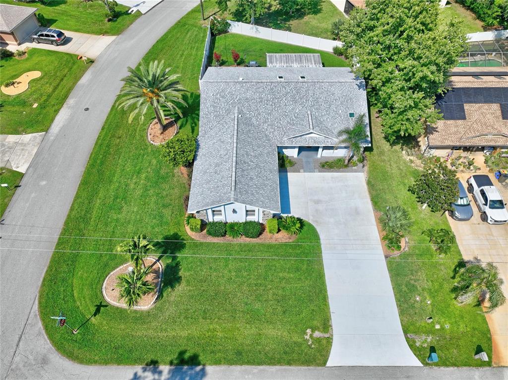 An aerial view shows a single-story house with a gray roof, driveway, and landscaped yard — 1 WASHWELL PLACE, PALM COAST, FL