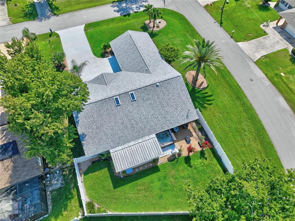 An aerial view of a house with a gray shingled roof, driveway, and fenced backyard — 1 WASHWELL PLACE, PALM COAST, FL