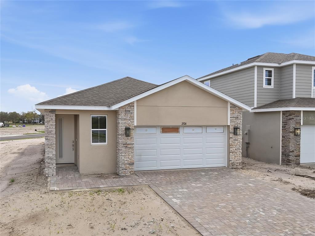 A single-story house features a stone-accented facade, a two-car garage, and a paved driveway — 2326 ANDERS DRIVE, PARRISH, FL