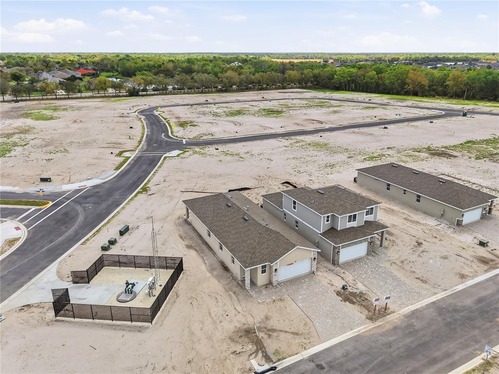 An aerial view shows two newly constructed houses and a fenced utility area in a development — 2326 ANDERS DRIVE, PARRISH, FL