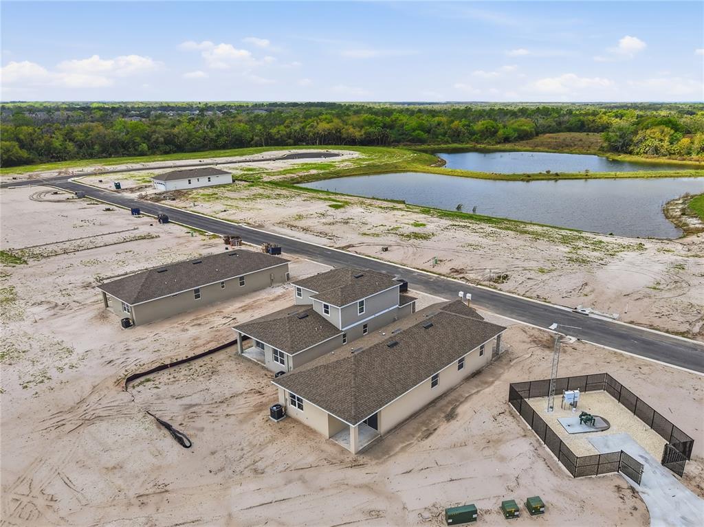 An aerial view shows several newly constructed houses on a sandy lot near a pond — 2326 ANDERS DRIVE, PARRISH, FL