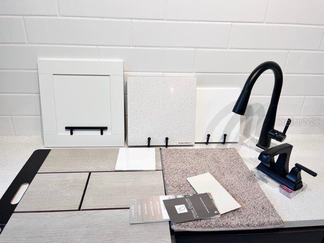 A display of interior design samples including cabinetry, countertops, flooring, carpet, and black plumbing fixtures — 2326 ANDERS DRIVE, PARRISH, FL