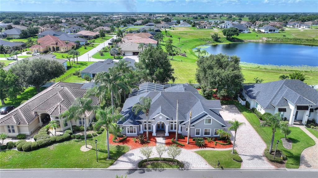 An aerial view of a suburban house with a gray roof and a paved driveway — 9469 WATERFORD OAKS DRIVE, WINTER HAVEN, FL