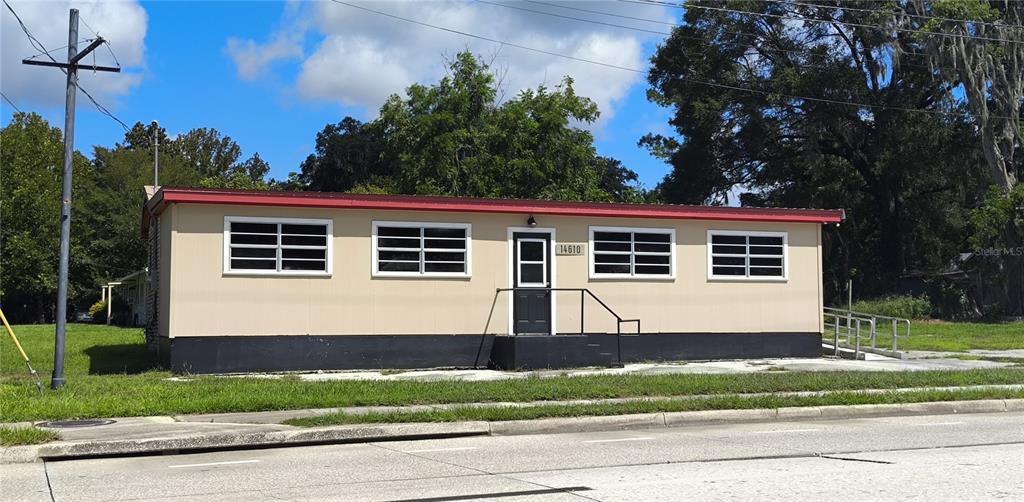A single-story building with tan siding, a red roof, and a black base — 14610 KENNARD STREET, WALDO, FL