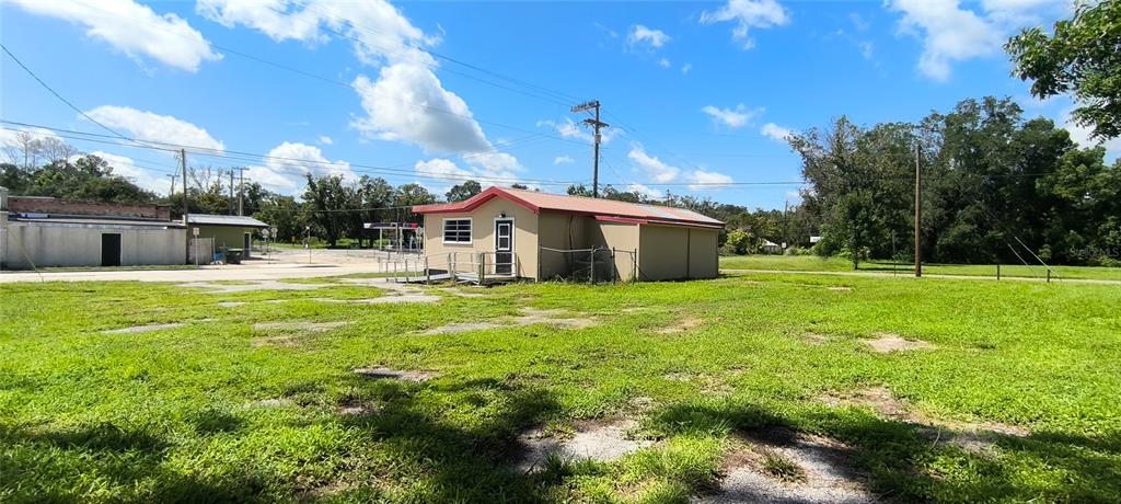 A tan commercial building with a red roof sits on a large, grassy lot — 14610 KENNARD STREET, WALDO, FL