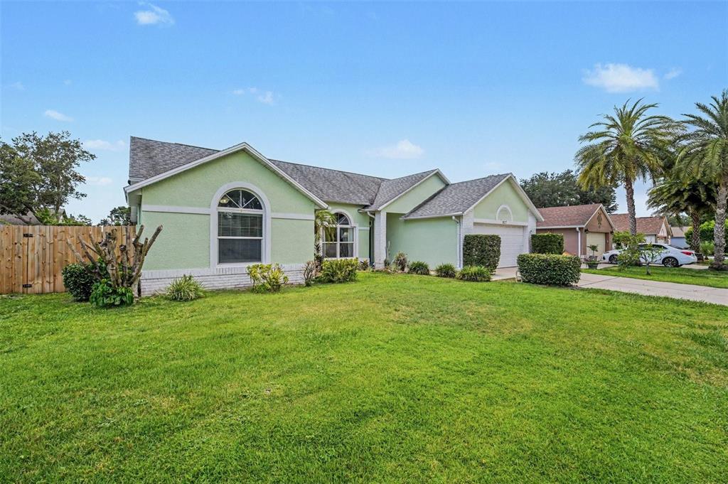 A light green single-story house with a shingled roof and a front lawn — 927 JAMESTOWN DRIVE, ROCKLEDGE, FL