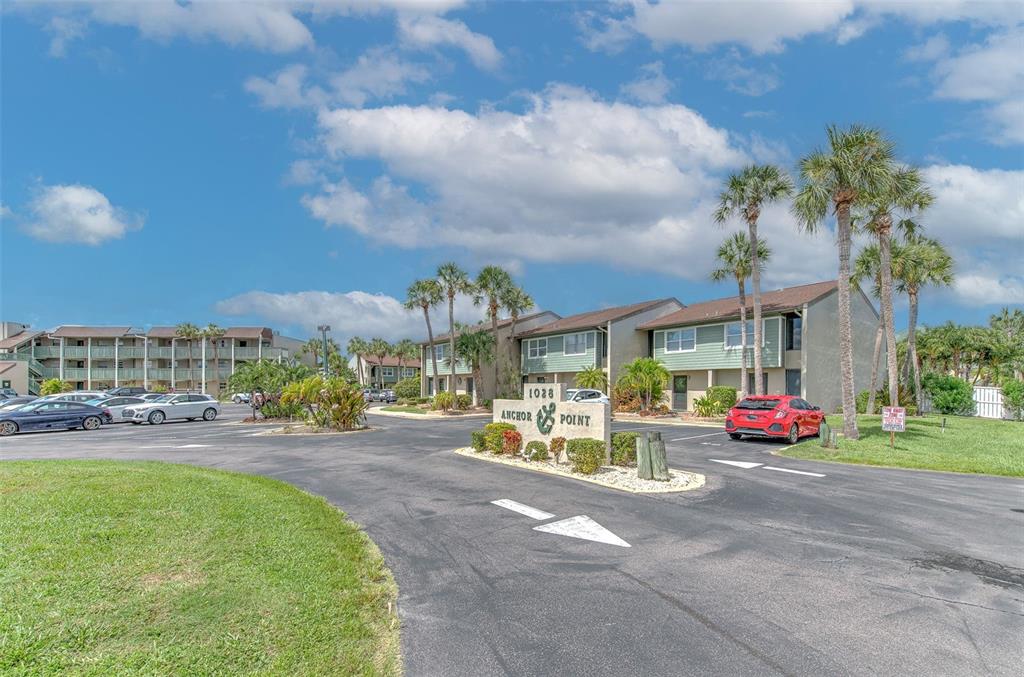 An exterior view of the Anchor Point apartment complex with a parking lot and palm trees — 1028 APOLLO BEACH BOULEVARD UNIT 4, APOLLO BEACH, FL