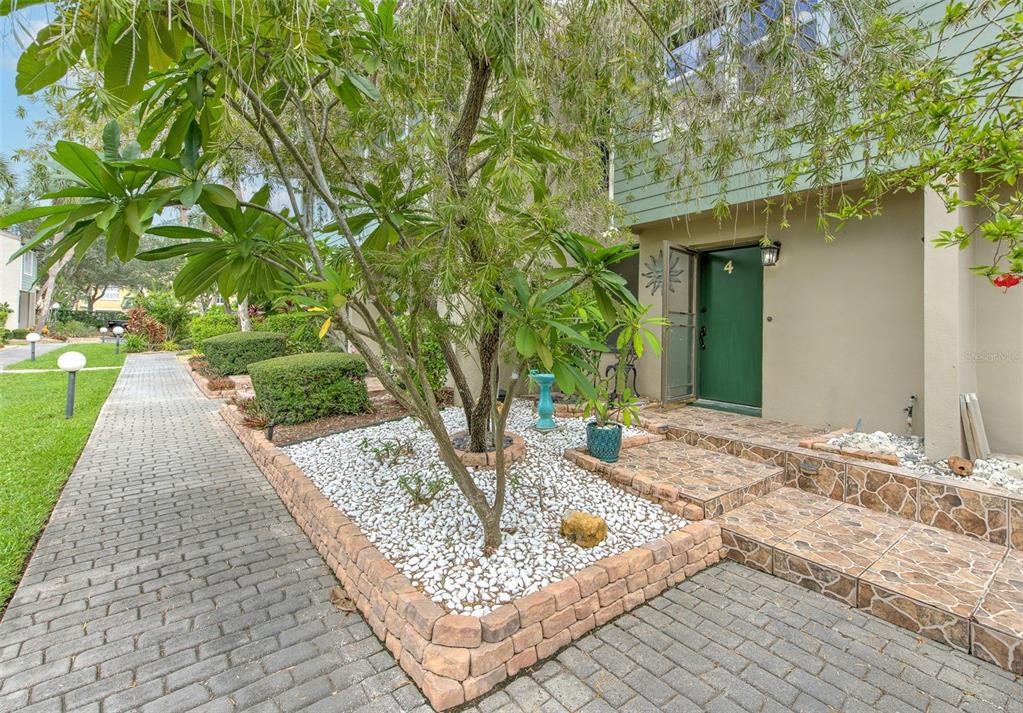 A paved walkway leads to the entrance of a residence with a green door — 1028 APOLLO BEACH BOULEVARD UNIT 4, APOLLO BEACH, FL