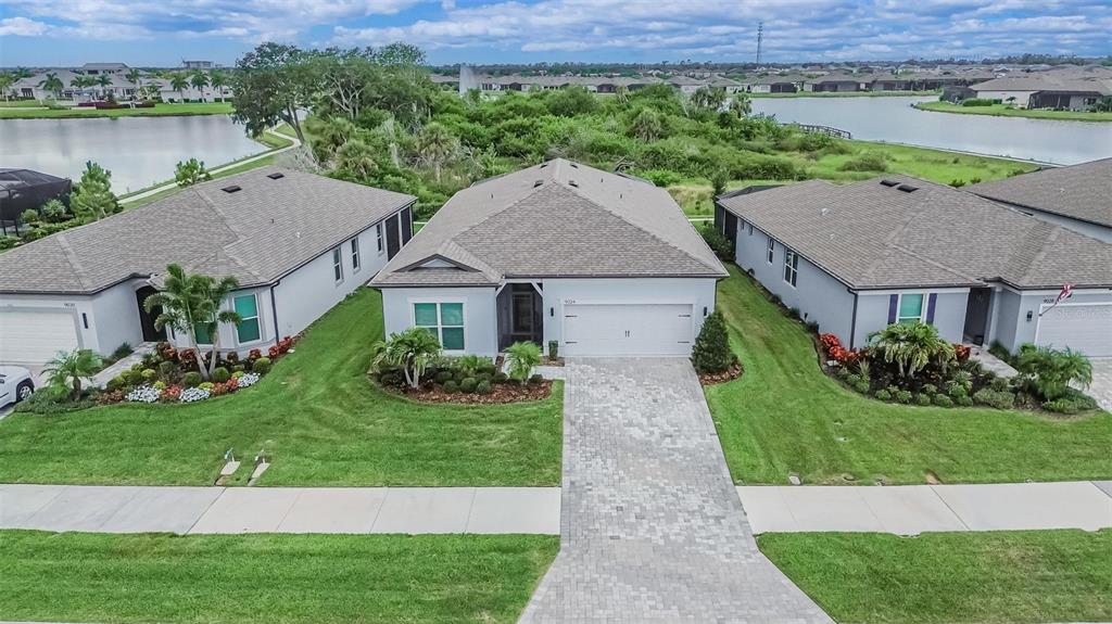 An aerial view of a suburban house with a paved driveway and a grassy lawn — 9024 BARRIER COAST TRAIL, PARRISH, FL