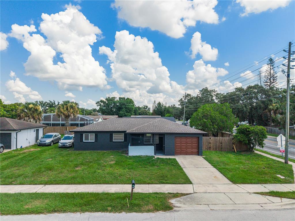 A single-story house with a dark gray exterior, brown roof, and attached garage — 2013 PATRICK STREET, KISSIMMEE, FL