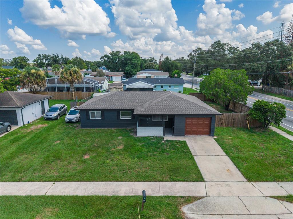 An aerial view shows a dark gray, single-story house with a brown roof and garage — 2013 PATRICK STREET, KISSIMMEE, FL