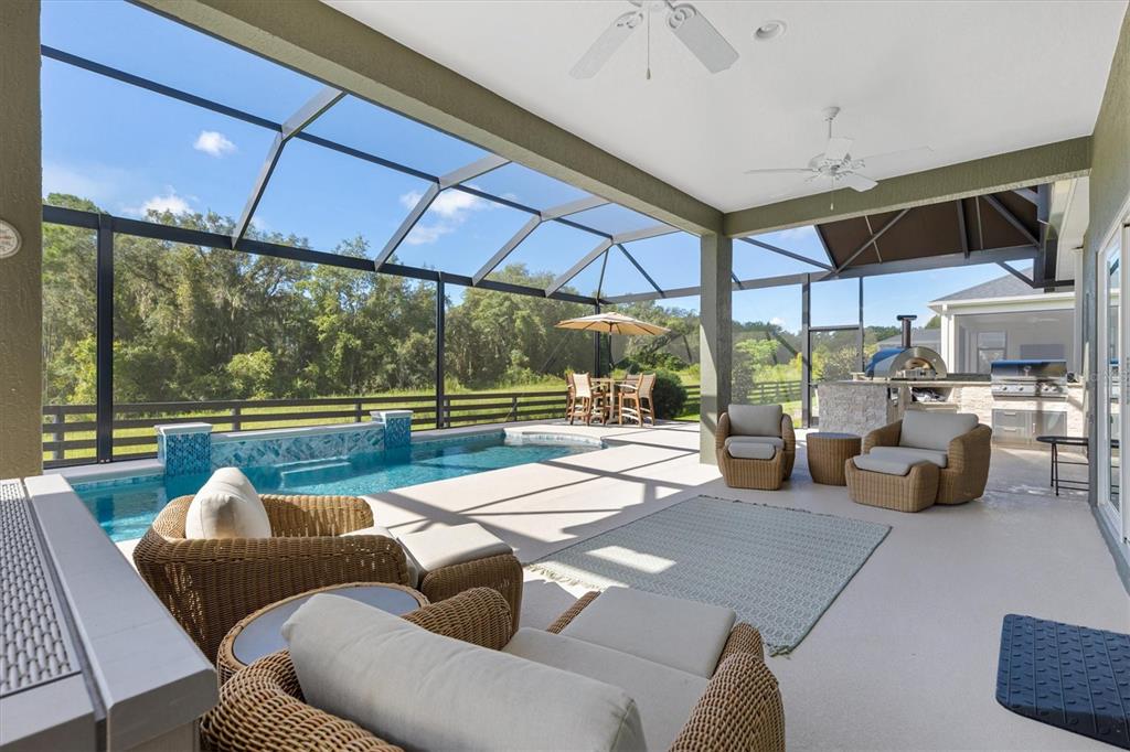 A gray single-story house with a three-car garage and a concrete driveway under a blue sky — 504 BEDMINSTER WAY, THE VILLAGES, FL