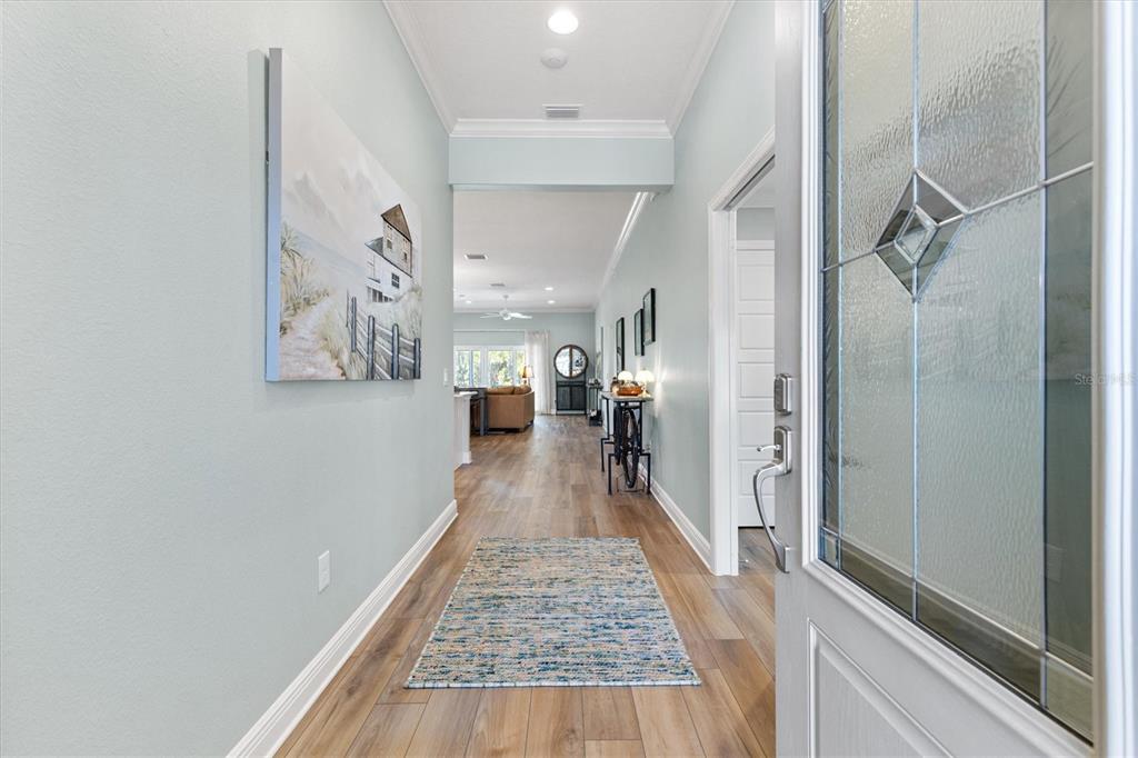 A screened-in pool area features a tiled water feature, patio furniture, and a fenced backyard — 504 BEDMINSTER WAY, THE VILLAGES, FL