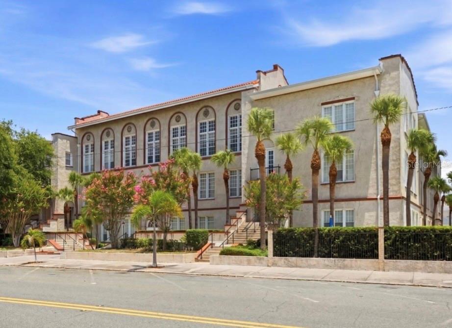 A three-story stucco apartment building with arched windows and palm trees in front — 701 MIRROR LAKE DRIVE N UNIT 317, ST PETERSBURG, FL