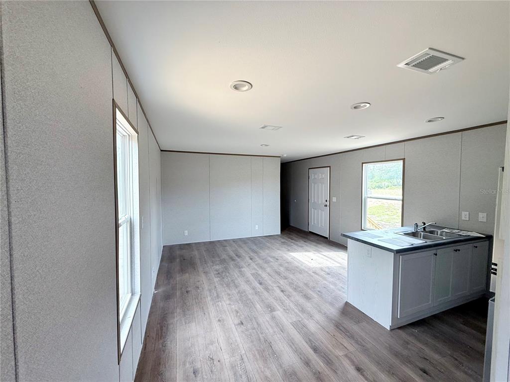 A laundry room features wood-look flooring, a wire shelf, and washer and dryer hookups — 6470 NE 115TH AVENUE, WILLISTON, FL