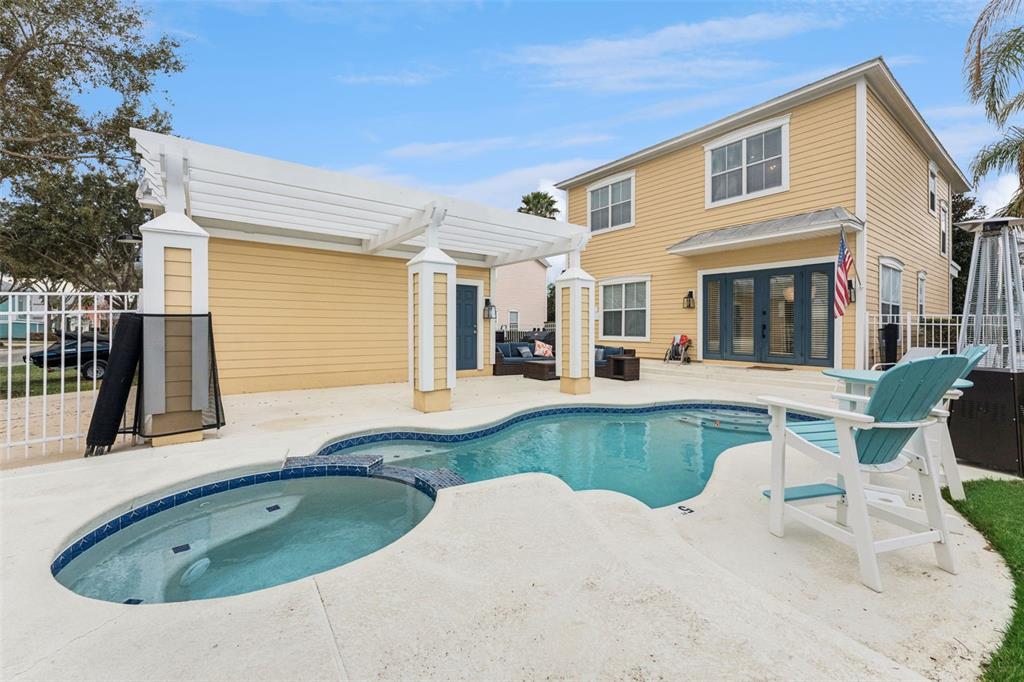 A two-story yellow house features a backyard swimming pool, spa, and a white pergola — 1440 FAIRVIEW CIRCLE, KISSIMMEE, FL