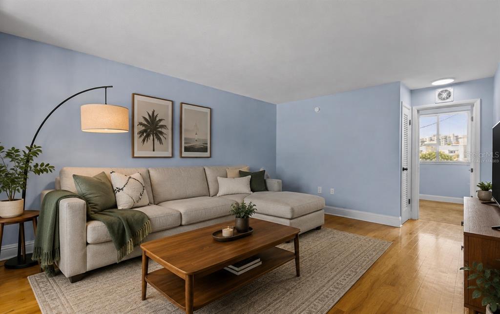 A living room features a light-colored sectional sofa, a wooden coffee table, and blue walls — 1301 S HOWARD AVENUE UNIT B18, TAMPA, FL