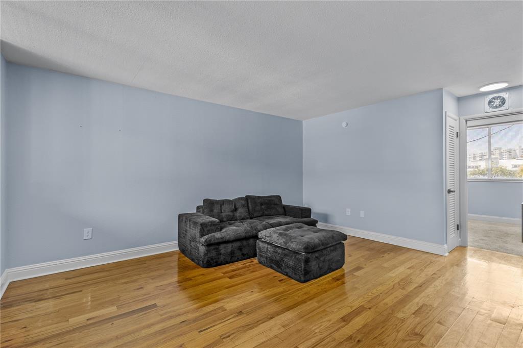 A living room with light blue walls, hardwood floors, and a dark gray sectional sofa — 1301 S HOWARD AVENUE UNIT B18, TAMPA, FL