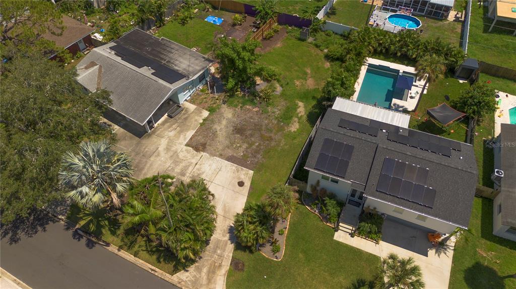 An aerial view shows two houses with solar panels, swimming pools, and driveways — HELENA STREET NE, ST PETERSBURG, FL