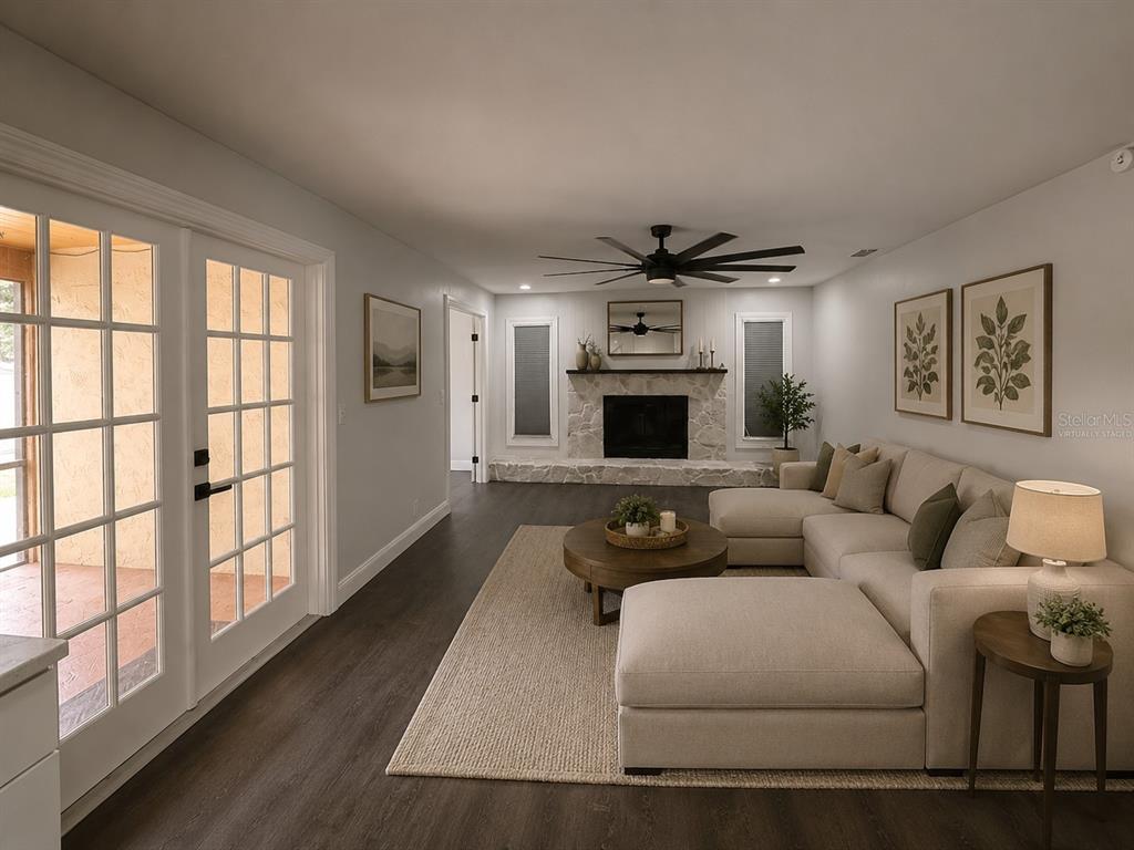 A modern kitchen features white cabinetry, a large island, stainless steel appliances, and dark flooring — 1809 STELLA COURT N, LAKELAND, FL