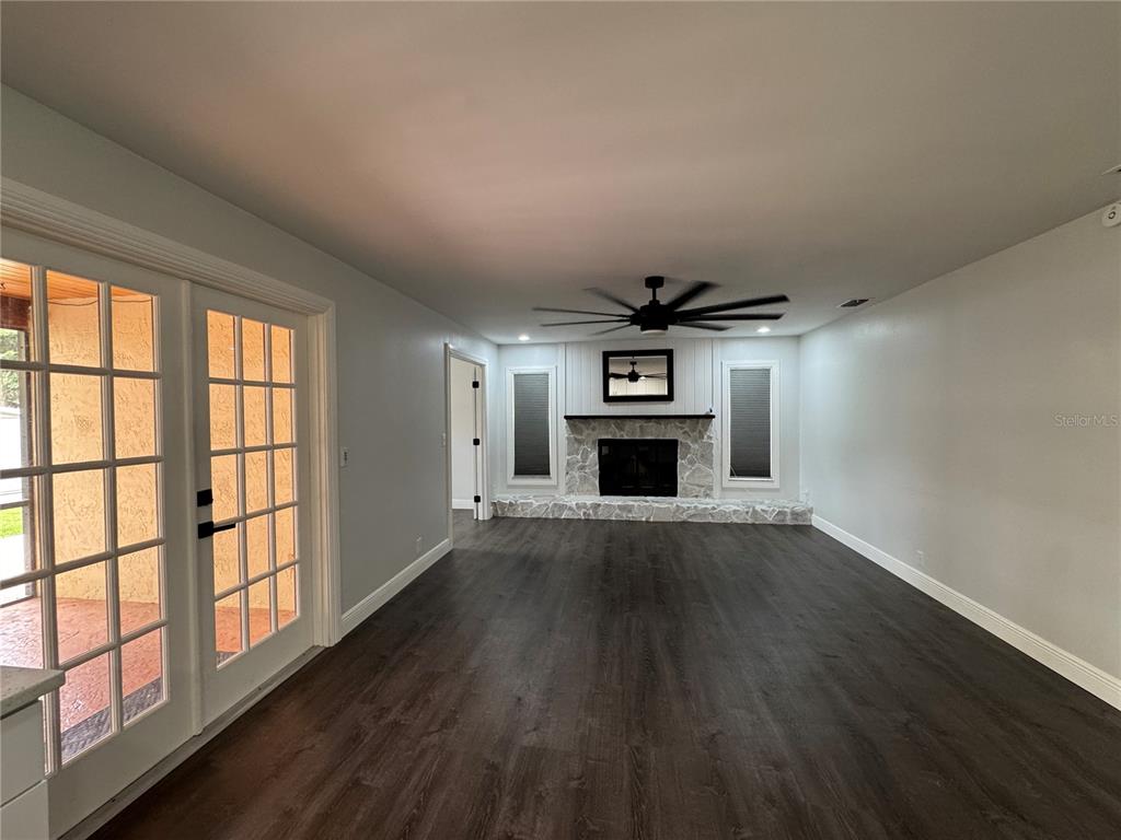 A modern kitchen features white cabinets, stainless steel appliances, marble-style backsplash, and dark wood flooring — 1809 STELLA COURT N, LAKELAND, FL