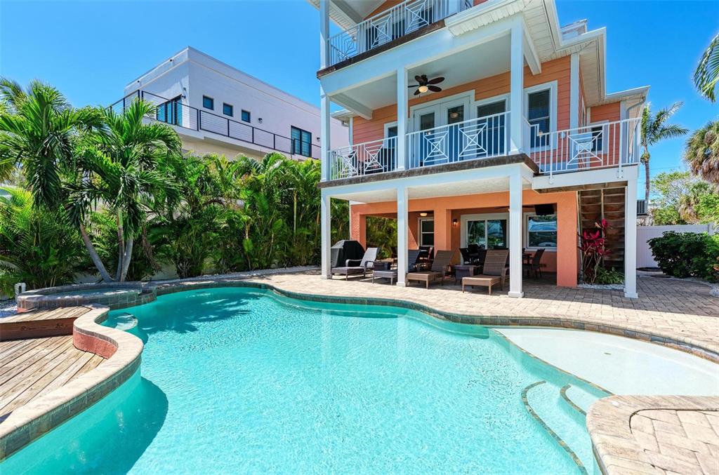 A multi-story peach-colored house with a swimming pool and a covered patio area — 203 N HARBOR DRIVE, HOLMES BEACH, FL