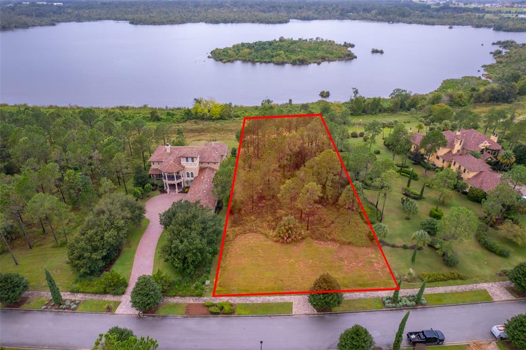 An aerial view shows a vacant, wooded residential lot outlined in red next to a house — 16325 PENDIO DRIVE, MONTVERDE, FL