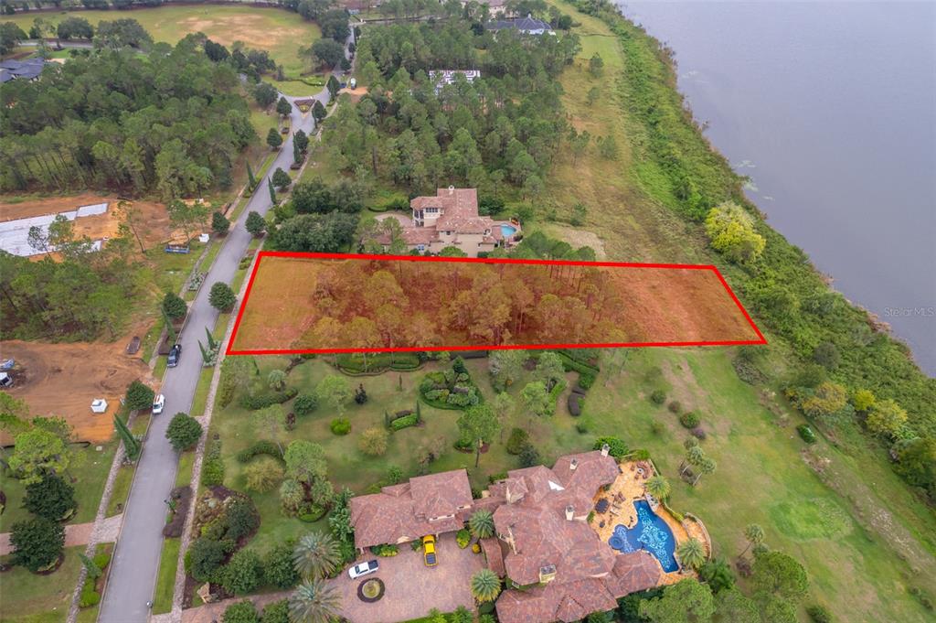 An aerial view shows a rectangular wooded lot outlined in red next to a lake — 16325 PENDIO DRIVE, MONTVERDE, FL