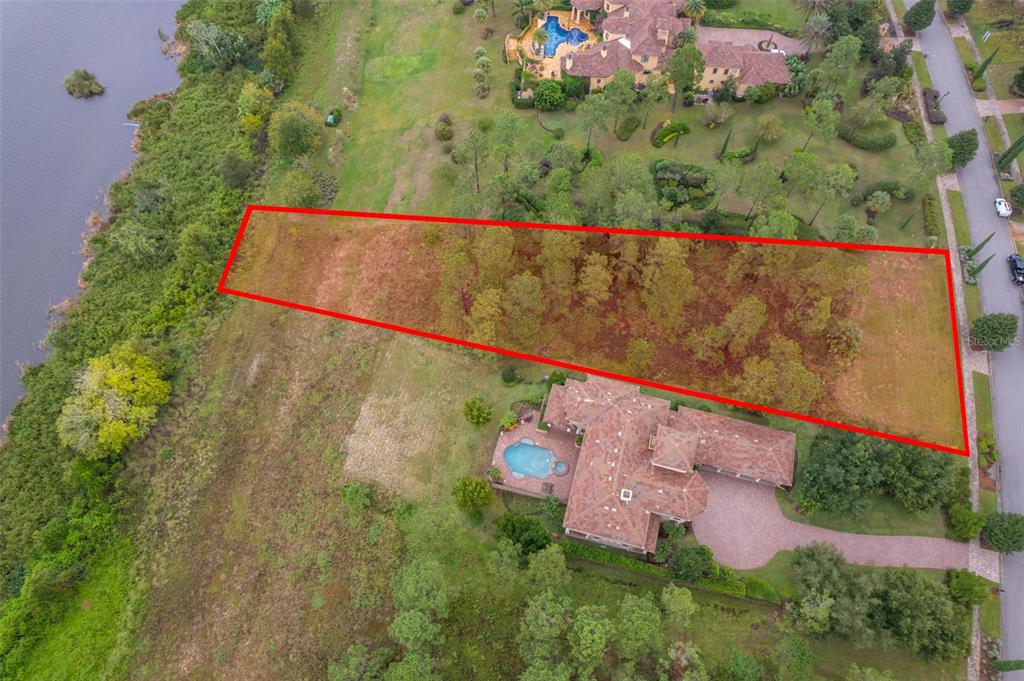 An aerial view shows a rectangular vacant lot outlined in red next to a large house — 16325 PENDIO DRIVE, MONTVERDE, FL