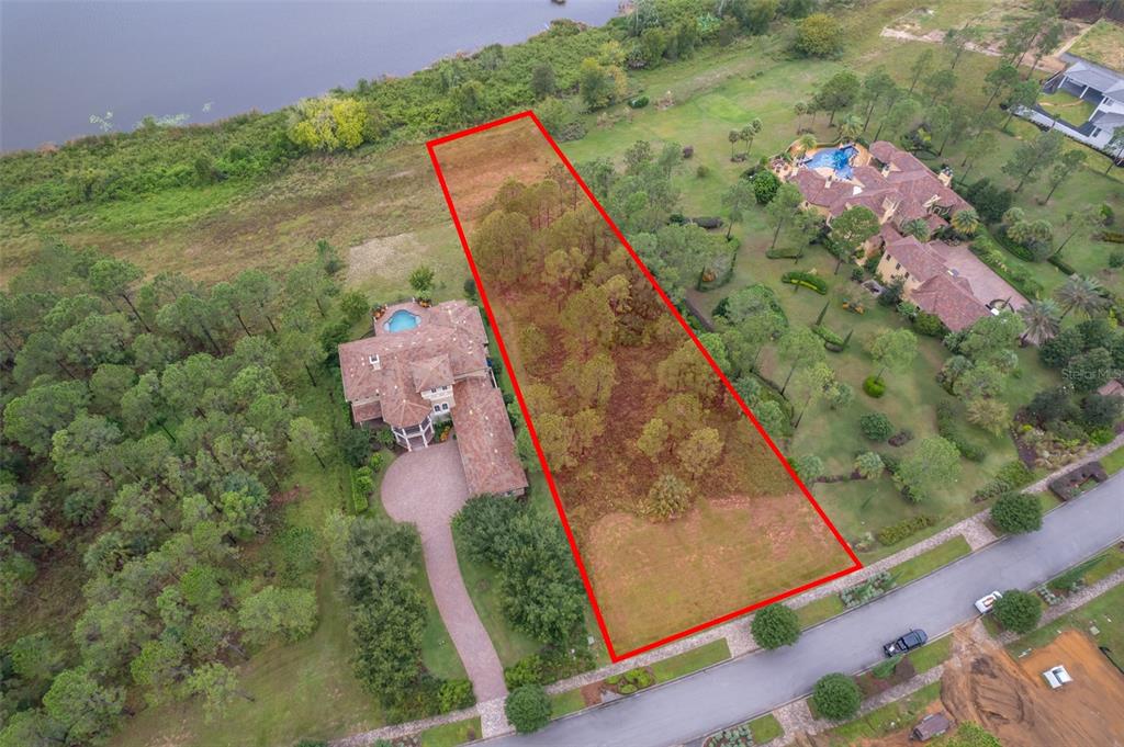 An aerial view shows a rectangular vacant lot outlined in red between two large houses — 16325 PENDIO DRIVE, MONTVERDE, FL