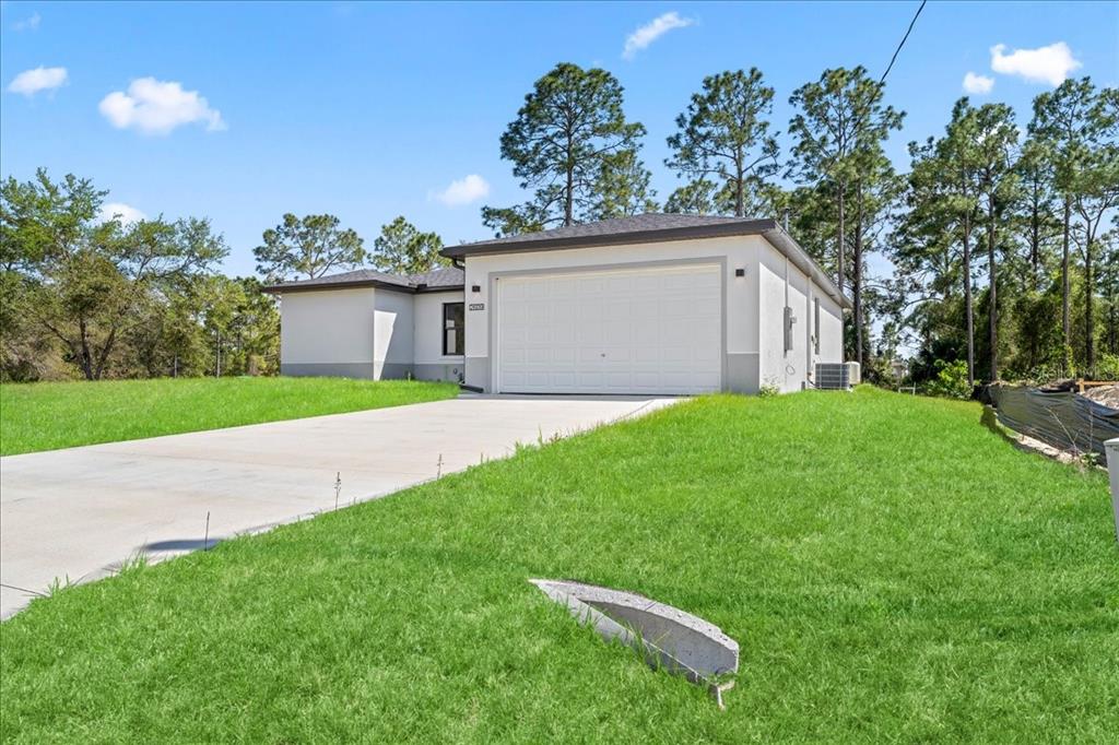 A single-story house with a white stucco exterior and a two-car garage — 2914 67TH STREET W, LEHIGH ACRES, FL