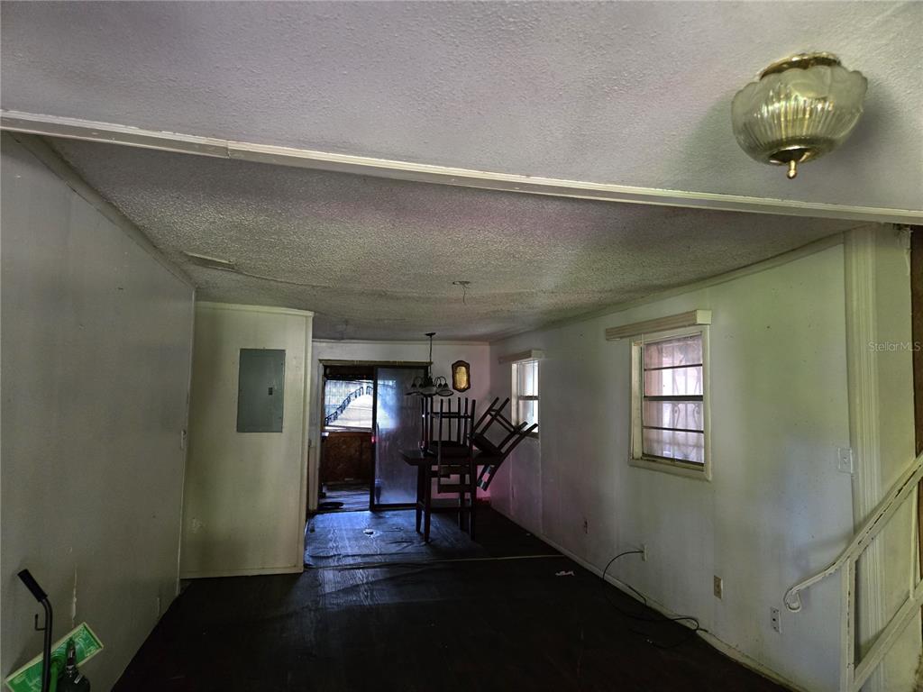 An interior view of a room with dark flooring, white walls, and a ceiling light fixture — 6981 HOLLY STREET, MOUNT DORA, FL