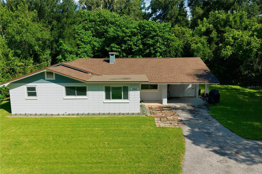 A single-story house with a white block exterior, brown roof, and an attached carport — 37047 OLD SAN ANN ROAD, DADE CITY, FL