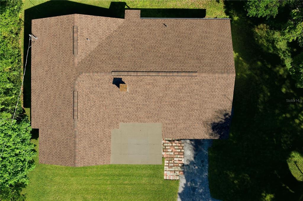 An aerial view shows the shingled roof of a house with a brick chimney — 37047 OLD SAN ANN ROAD, DADE CITY, FL