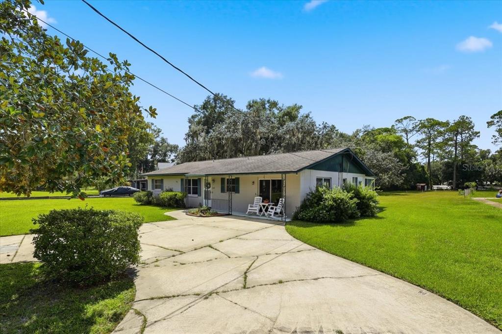 A single-story house with a concrete driveway and a large grassy yard — 2228 RIVER RIDGE ROAD, DELAND, FL