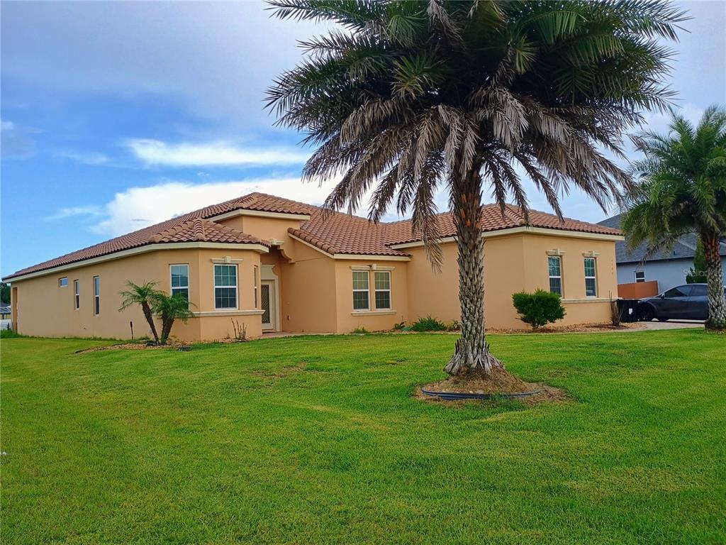 A single-story tan stucco house with a tile roof and a large palm tree — 4394 PRESERVATION CIRCLE, MELBOURNE, FL
