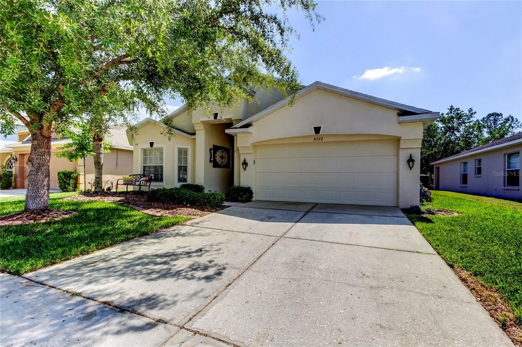 A single-story suburban house with a beige stucco exterior, a two-car garage, and a driveway — 4522 LISETTE CIRCLE, BROOKSVILLE, FL