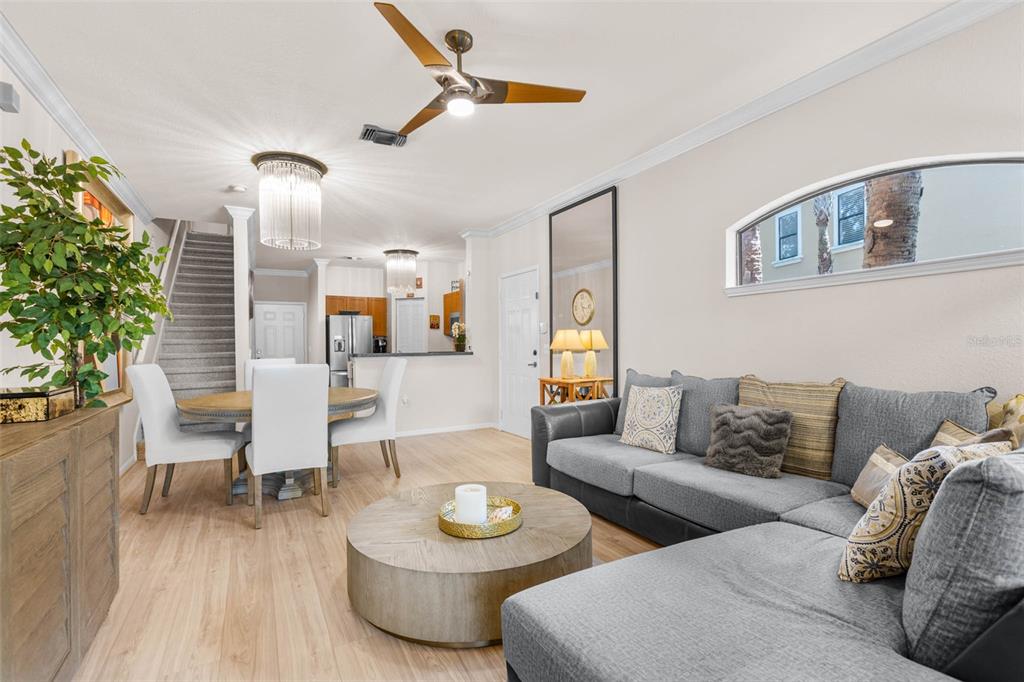 A living room with a gray sectional sofa, round coffee table, and adjacent dining area — 2176 PORTOFINO PLACE UNIT 6-2612, PALM HARBOR, FL