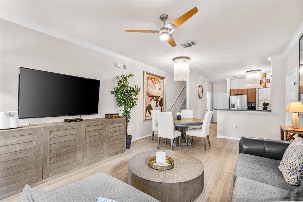 A living room and dining area with wood-look flooring, a ceiling fan, and modern furniture — 2176 PORTOFINO PLACE UNIT 6-2612, PALM HARBOR, FL