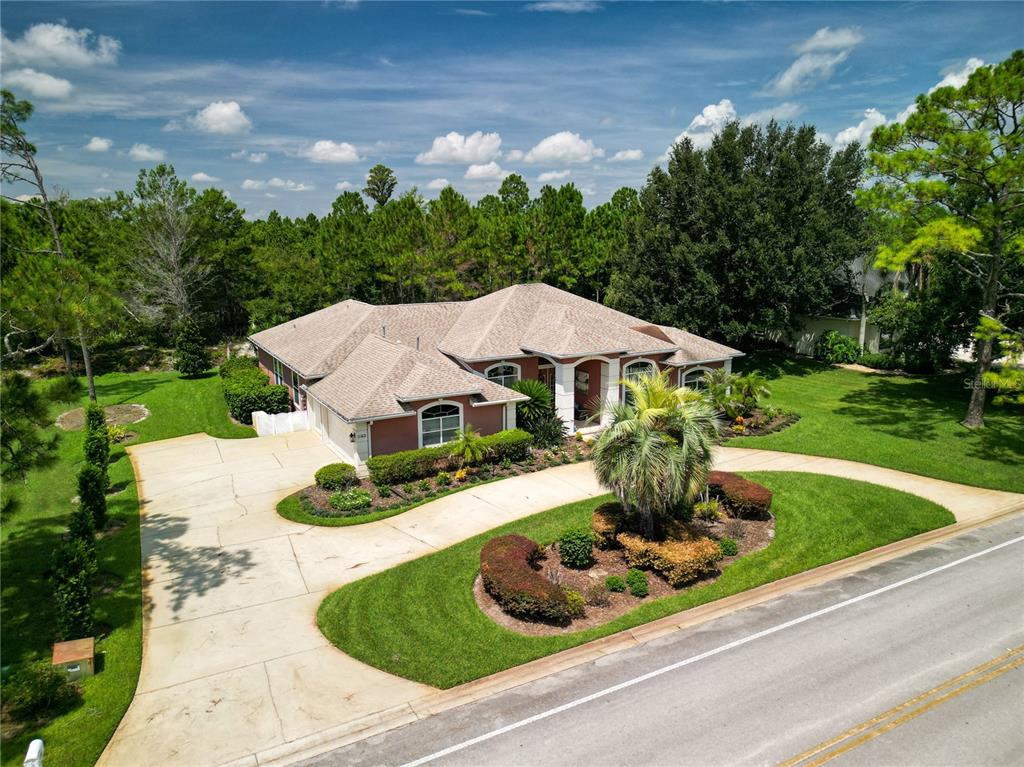 An aerial view of a single-story house with a circular driveway and landscaped front yard — 1162 CLUB HOUSE BOULEVARD, NEW SMYRNA BEACH, FL