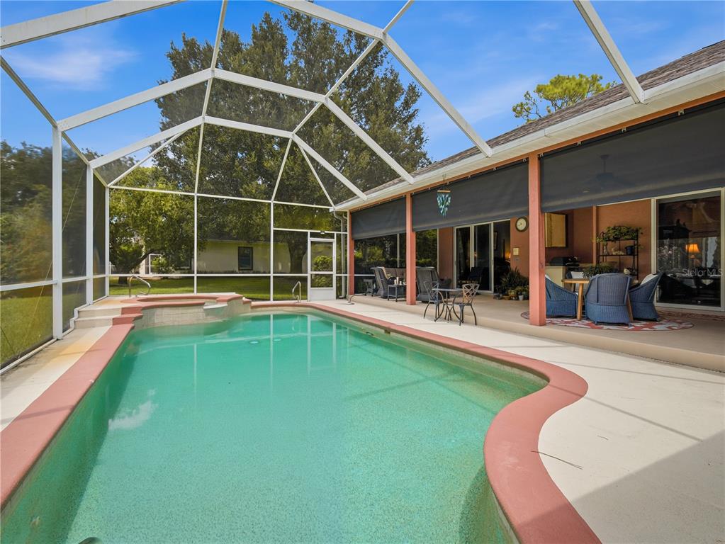 A screened-in patio features a swimming pool, a hot tub, and outdoor furniture — 1162 CLUB HOUSE BOULEVARD, NEW SMYRNA BEACH, FL