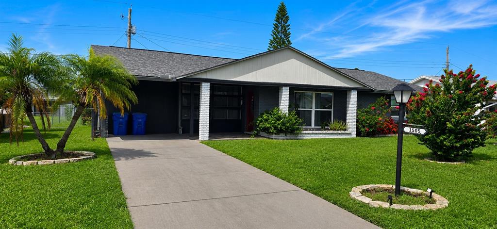 A single-story house with a gray exterior, white brick columns, and a concrete driveway — 1505 ARROWHEAD DRIVE, SUN CITY CENTER, FL
