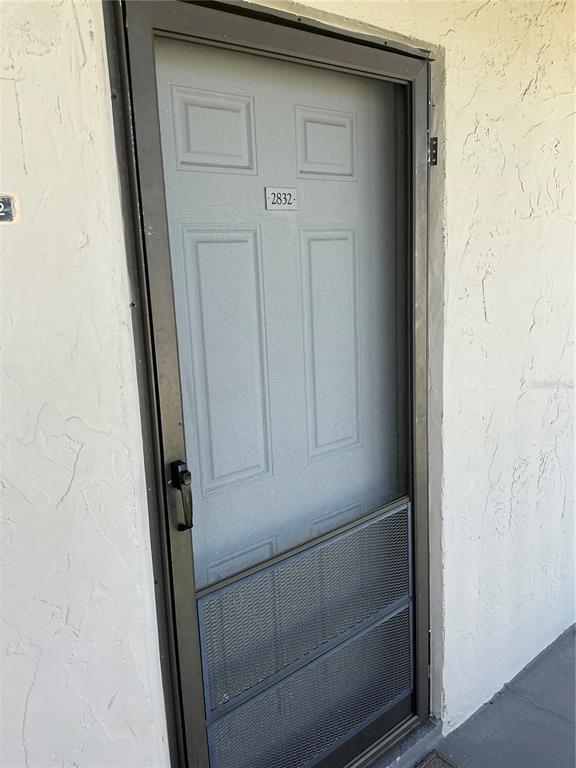 A gray door with a screen door and the number 2832 is set in a wall — 2625 STATE ROAD 590 UNIT 2832, CLEARWATER, FL