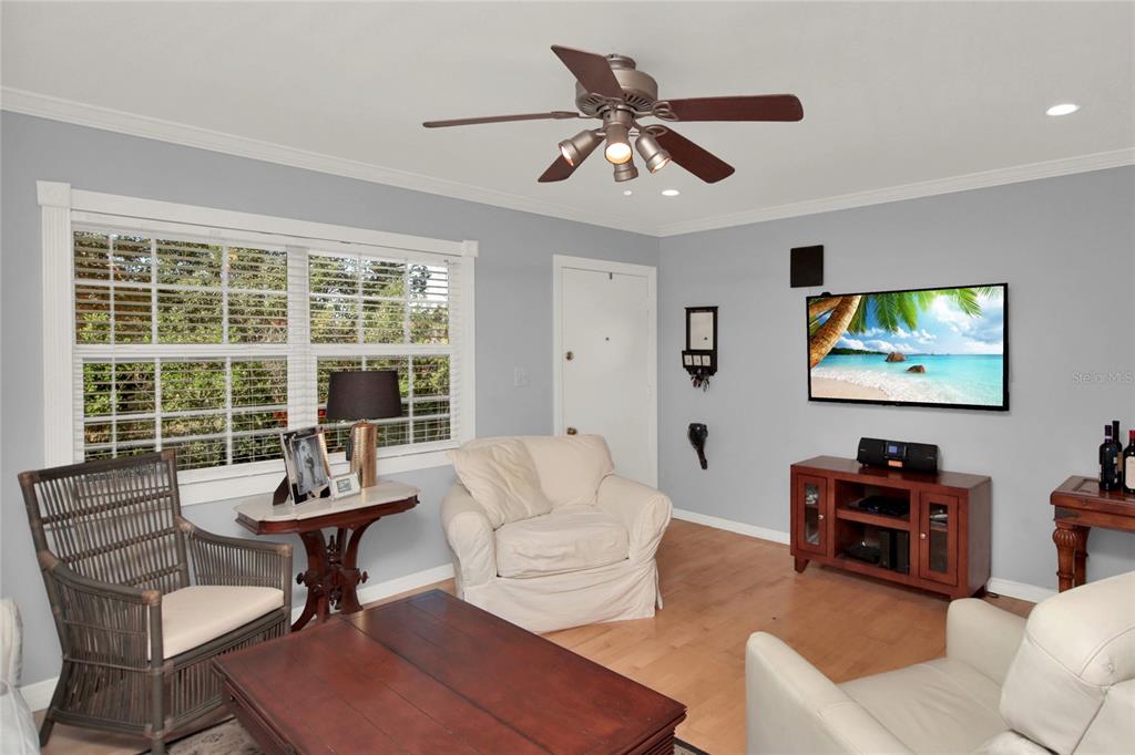 A living room features light gray walls, a ceiling fan, and a wall-mounted television — 2500 LEE RD. UNIT 222, WINTER PARK, FL